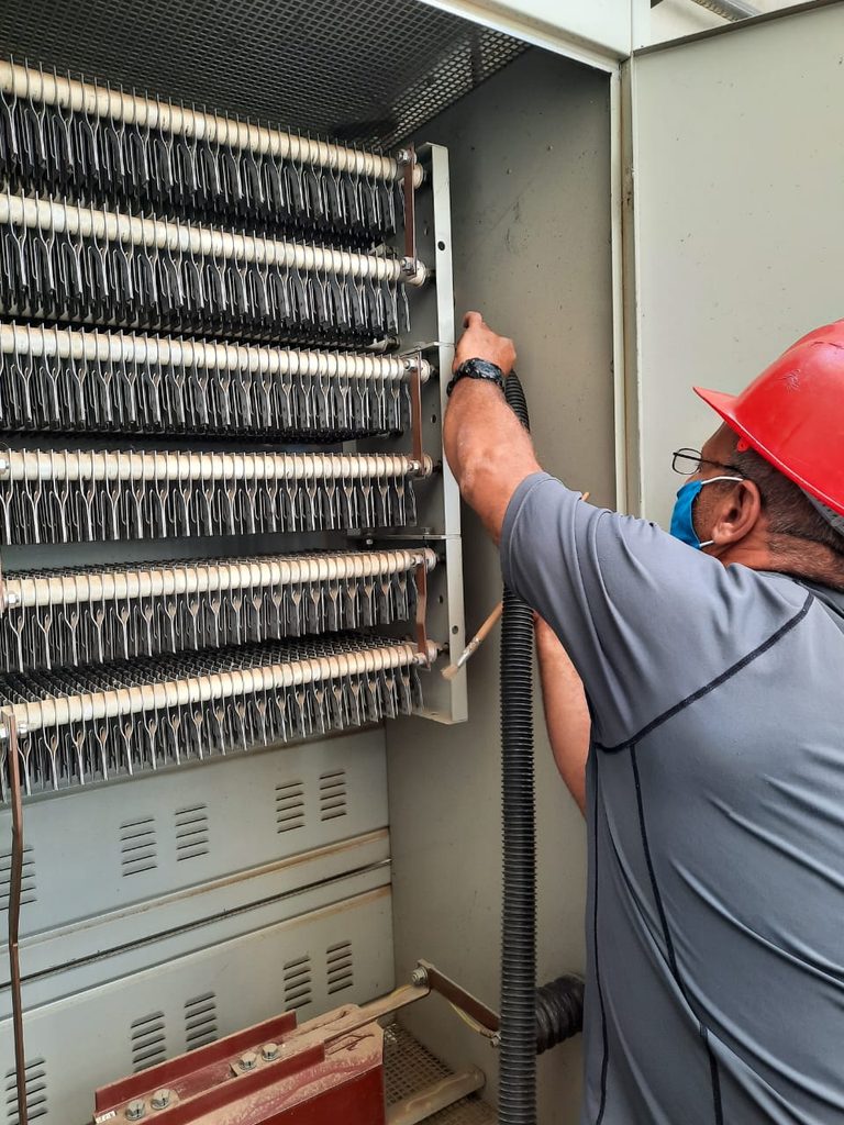 Técnico electricista realizando conexión y cableado en gabinete de control industrial